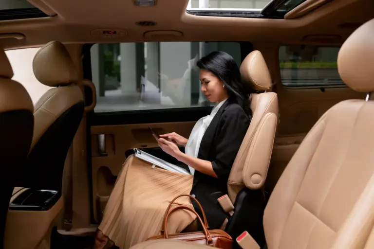 businesswoman-sitting-backseat-taxi-scaled